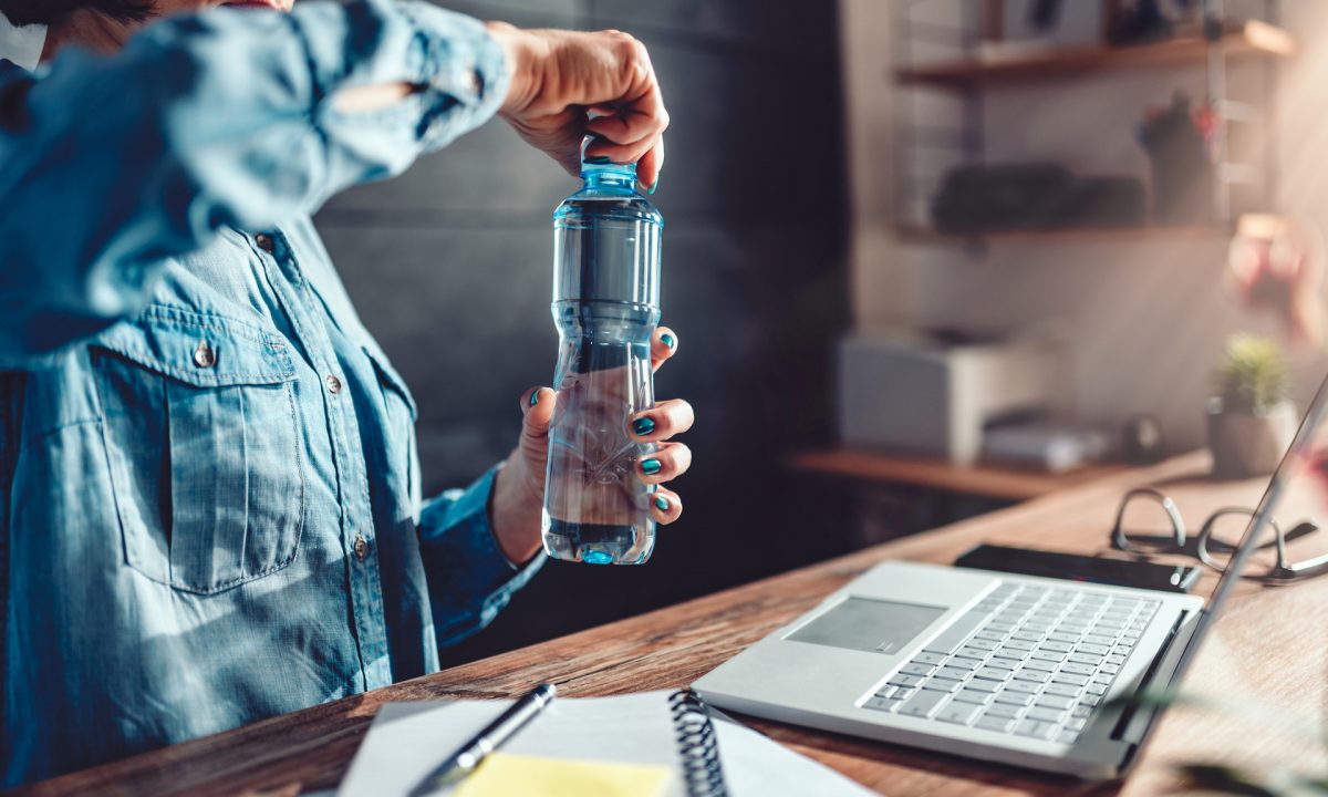 Пляшка води в руці дівчини