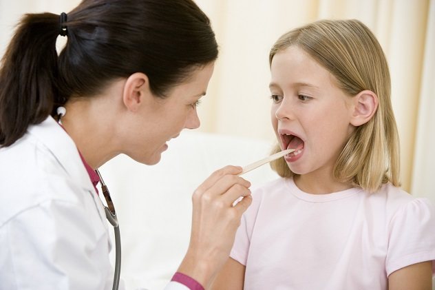 Доктор перевіряє горло у дівчинки