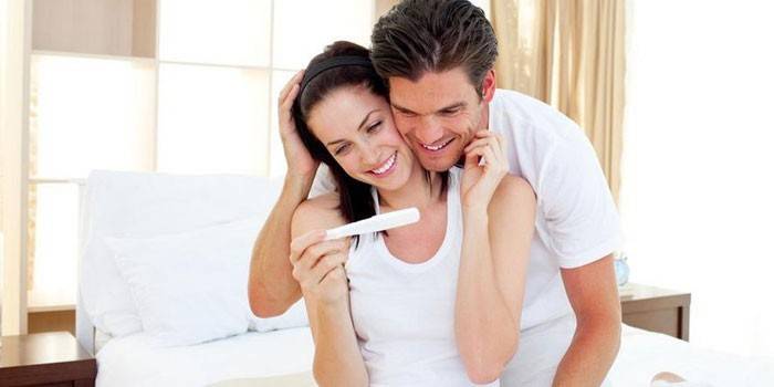 Чоловік і жінка з тестом на вагітність в руках