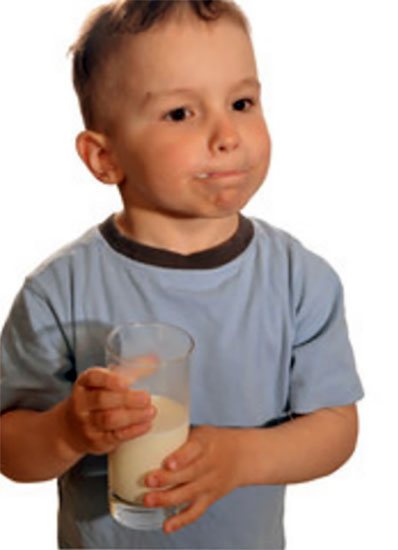 Незадоволений хлопчик зі склянкою молока
