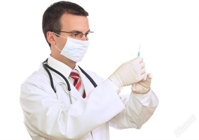 лікар тримає в руках шприц з розчином