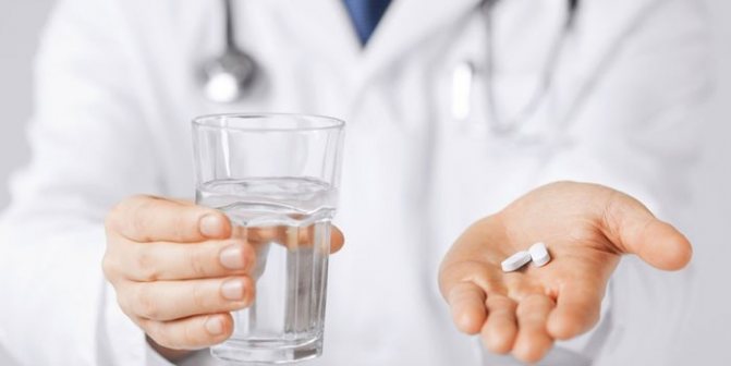 Лікар з таблетками і склянкою води