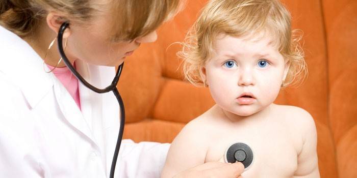 Лікар слухає легені маленької дитини фонендоскопом